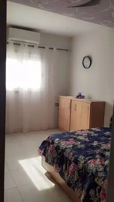 a bedroom with a bed and a clock on the wall at Evi's Infinity Sea View Apartment in Hurghada