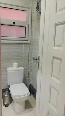 a bathroom with a white toilet and a window at Evi's Infinity Sea View Apartment in Hurghada