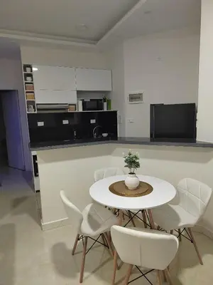 a dining room with a table and white chairs at Velký apartmán Princess Resort Hurghada in Hurghada