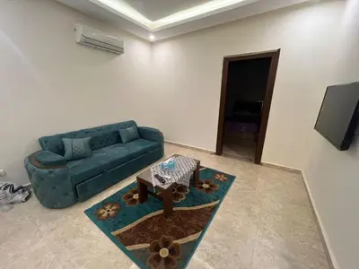 a living room with a blue couch and a table at Mirage bay in Hurghada