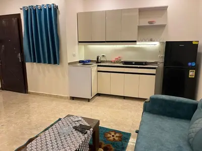a small kitchen with a black refrigerator and a table at Mirage bay in Hurghada