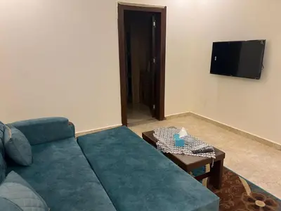 a living room with a blue couch and a table at Mirage bay in Hurghada