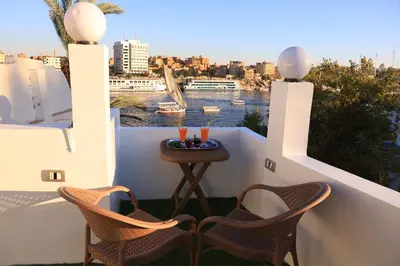a balcony with two chairs and a table with candles at Crystala guest house in Aswan