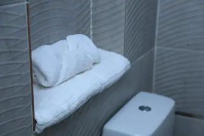 a bathroom with white towels on a shelf next to a toilet at Crystala guest house in Aswan