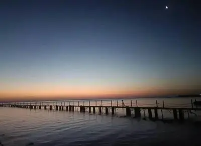 a pier on the water with the sunset in the background at Fox Resort El Gouna Stay in Hurghada