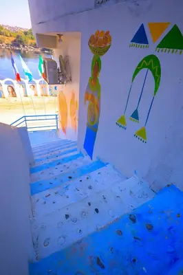 a group of stairs with colorful paintings on the wall at Nubian Popeye - Roof top - Nile View in Aswan