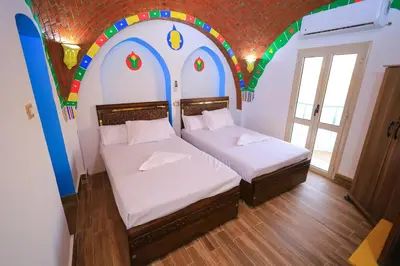 two beds in a room with a colorful ceiling at Nubian Popeye - Roof top - Nile View in Aswan