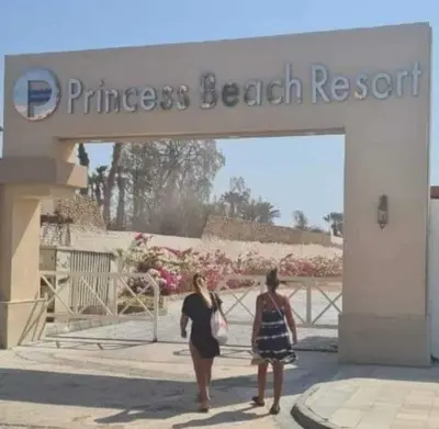 two women walking out of a entrance to a purchase beach resort at Hotel Room in Princess Resort With Beach Acces & Free Wi-fi I Near Air port in Hurghada