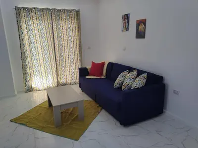 a living room with a blue couch and a table at Condo with Breathtaking 's view with 2 bedrooms in Hurghada