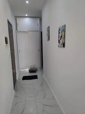 a hallway with a white refrigerator and a tile floor at Condo with Breathtaking 's view with 2 bedrooms in Hurghada