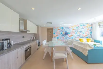 a kitchen with a table and a bed in a room at Beach-Inspired 1BR in Mangroovy, El Gouna. Sea & Pool in Hurghada