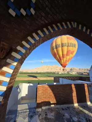 a hot air balloon is flying in the sky at Quiet Gate Guest House in Al Aqālitah