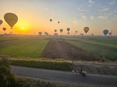 a group of hot air balloons flying over a field at Quiet Gate Guest House in Al Aqālitah