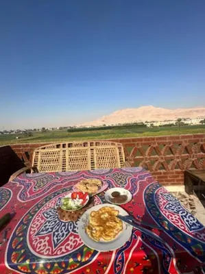a table with a plate of food on a table at Quiet Gate Guest House in Al Aqālitah