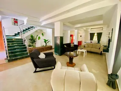 a living room with couches and chairs and a staircase at villa 5 in magawish in Hurghada