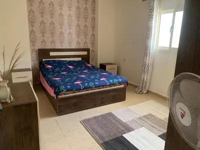 a bedroom with a bed in a room with a window at Alfayrouz house in Hurghada