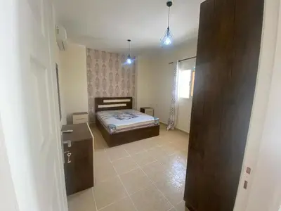 a bedroom with a bed in a room with a window at Alfayrouz house in Hurghada