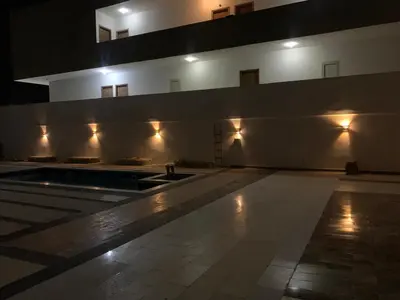 a large building with a swimming pool at night at Alfayrouz house in Hurghada