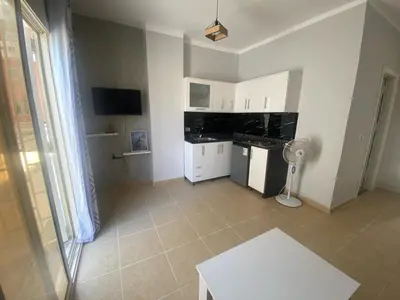 a kitchen with white cabinets and a tile floor at Alfayrouz house in Hurghada