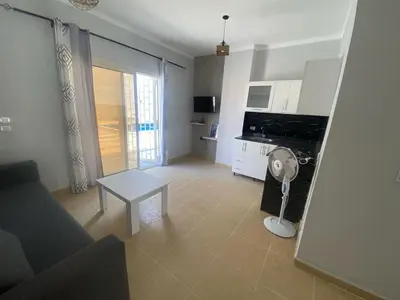 a living room with a table and a floor fan at Alfayrouz house in Hurghada