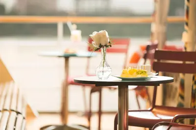 a table with a vase of flowers and a plate of food at M/Y ALYSSA - 4 or 7 Nights From Luxor each Monday and 3 or 7 Nights From Aswan each Friday in Luxor