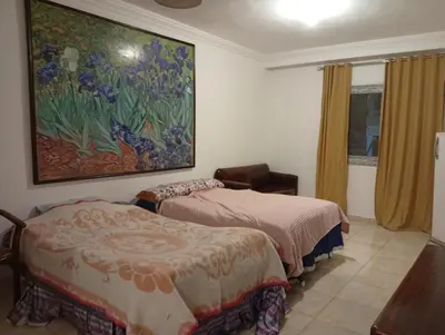 a bedroom with two beds and a painting on the wall at Sheraton Plaza Near Marina in Hurghada