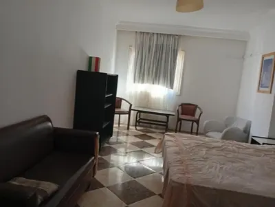 a bedroom with a bed and a couch and a table at Sheraton Plaza Near Marina in Hurghada
