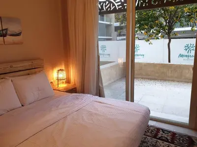 a bedroom with a bed and a large window at Mangroovy - 1BR Shiny Ground Floor in Hurghada