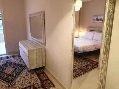 a mirror in a room with a bed and a bed sidx sidx sidx at Mangroovy - 1BR Shiny Ground Floor in Hurghada