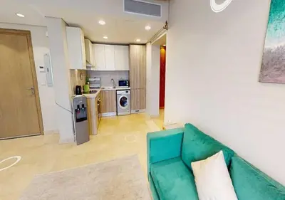 a living room with a green couch and a kitchen at Beautiful 2 Bed Rooms at Mangaroveey M7-4B-El-Gouna in Hurghada