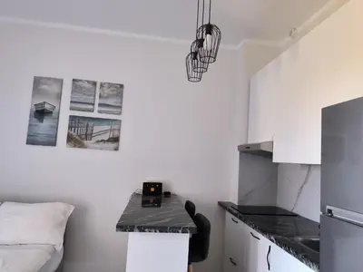 a kitchen with white walls and a black counter top at Solo beach front studio or for couple in Hurghada