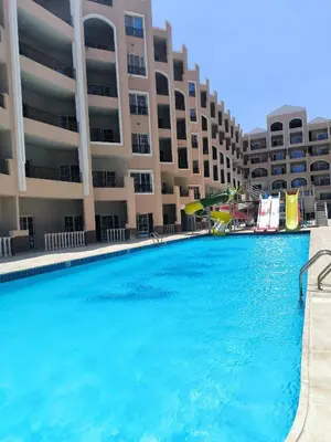 a large swimming pool in front of a building at Solo beach front studio or for couple in Hurghada