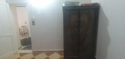 a wooden cabinet against a wall in a room at Seashell in Quseir