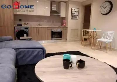 a living room with a table and a kitchen at Warm 1BR with @ Mangroovy, El-Gouna M1-7B in Hurghada