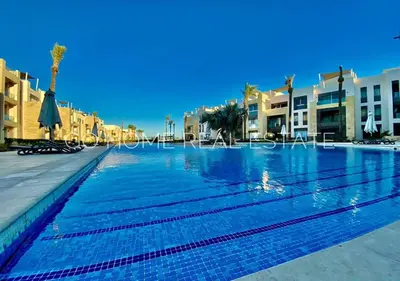 an empty swimming pool with palm trees and buildings at Warm 1BR with @ Mangroovy, El-Gouna M1-7B in Hurghada