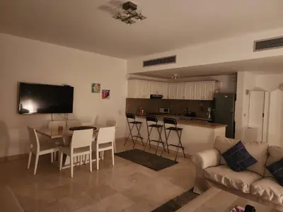 a living room with a couch and a table and a kitchen at Elgouna - Directly To The Marina in Hurghada