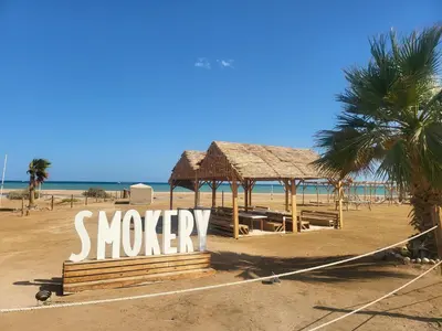 a sign on a beach with a palm tree at Elgouna - Directly To The Marina in Hurghada