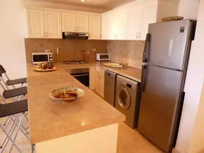 a kitchen with a refrigerator and a bowl of fruit on the counter at Elgouna - Directly To The Marina in Hurghada
