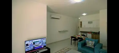 a living room with a blue chair and a television at La BONITA FLAT in Hurghada