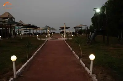 a pathway with lights in a park at night at Fox Beach Stay in Hurghada
