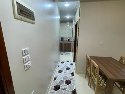 a hallway with a table and a tv on a wall at White Star House in Safaga