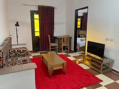 a living room with a television and a red rug at White Star House in Safaga