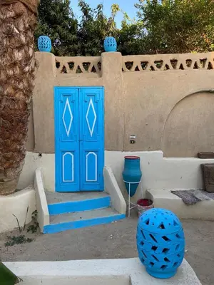 a blue door with stairs in front of a house at Villa Rebecca Professor's paradise in Luxor