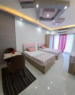a bedroom with two beds and a table and a projector at Juliana beach resort in el ahead st in El Gouna