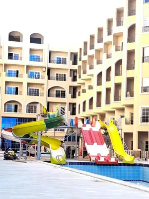 a pool with a slide in front of a hotel at Juliana beach resort in el ahead st in El Gouna
