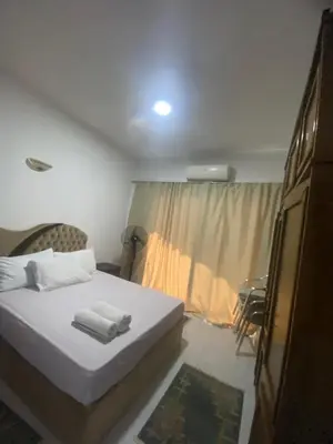 a bedroom with a white bed and a window at Fox House Resort Apartment in Hurghada
