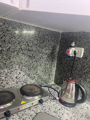 a stove top with a tea kettle on a counter at Fox house resort Apartment hotel in Hurghada