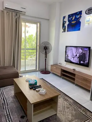 a living room with a tv and a table at Fox house resort Apartment hotel in Hurghada