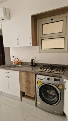 a kitchen with a stove and a washing machine at La bonita studio b1 in Hurghada