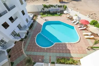 an overhead view of a swimming pool in front of a building at La bonita studio b1 in Hurghada